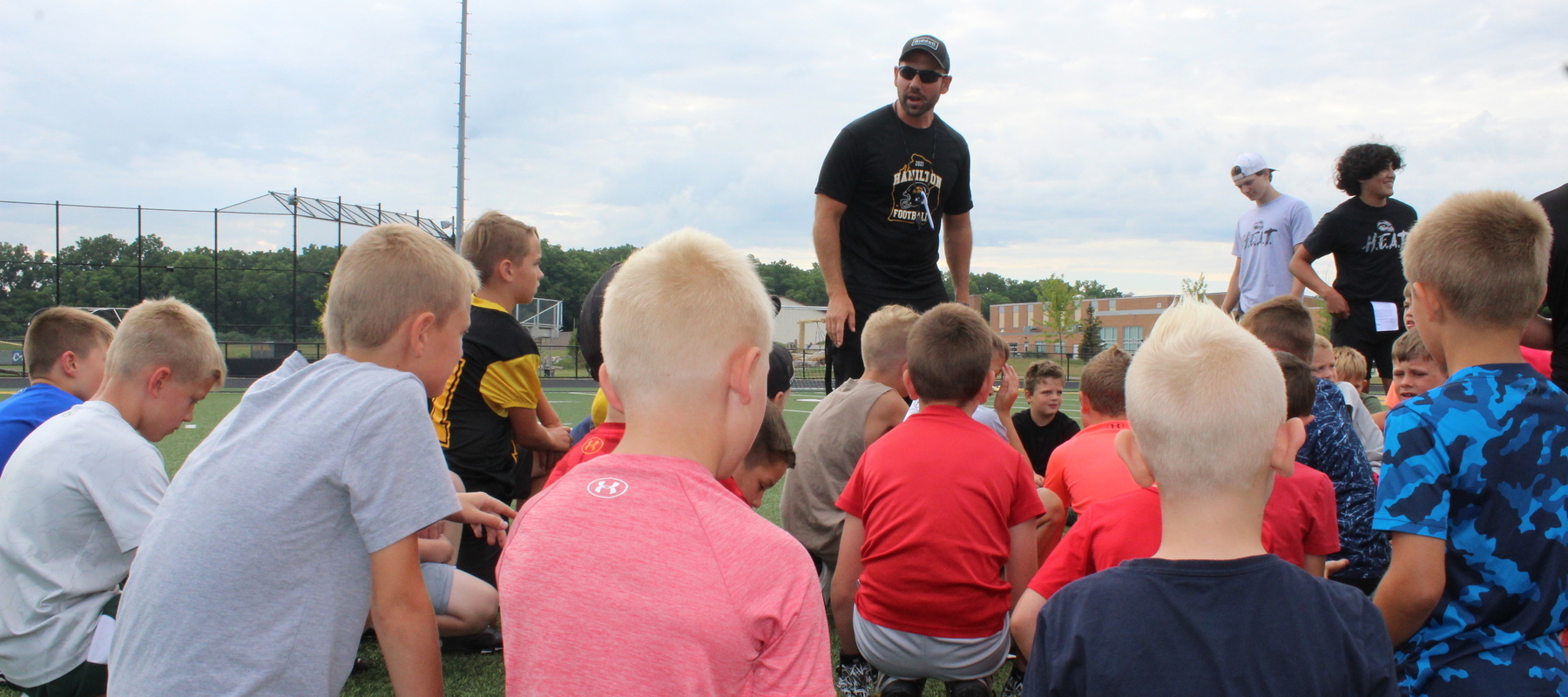 Varsity head football coach Phil Koops addresses the campers at the program's 'Kids Day' camp.