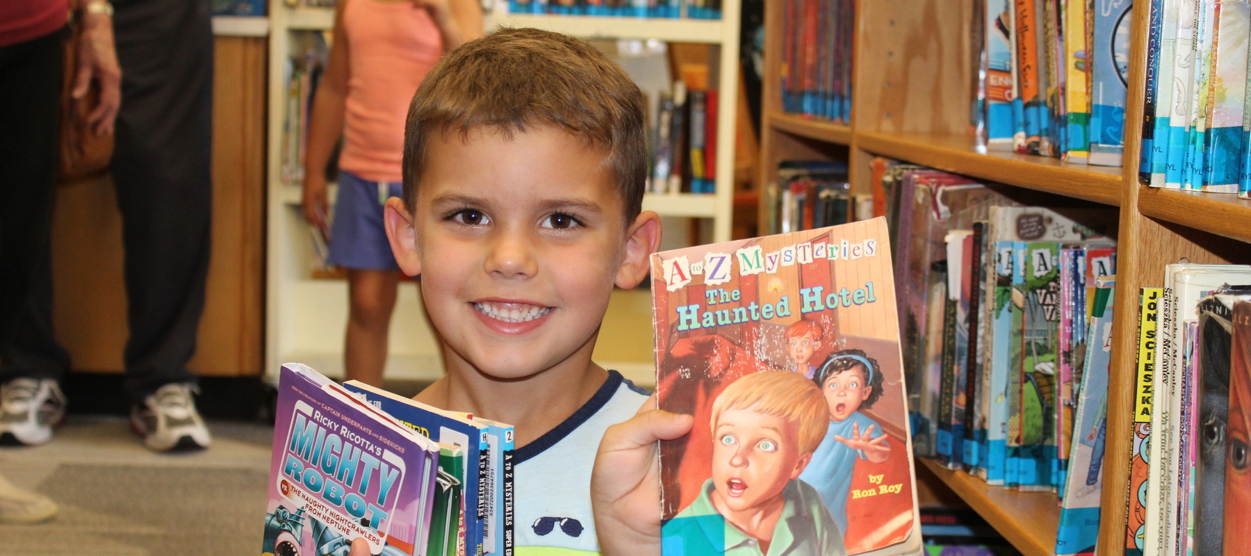A young student enjoys his trip to the Hamilton Elementary summer library.