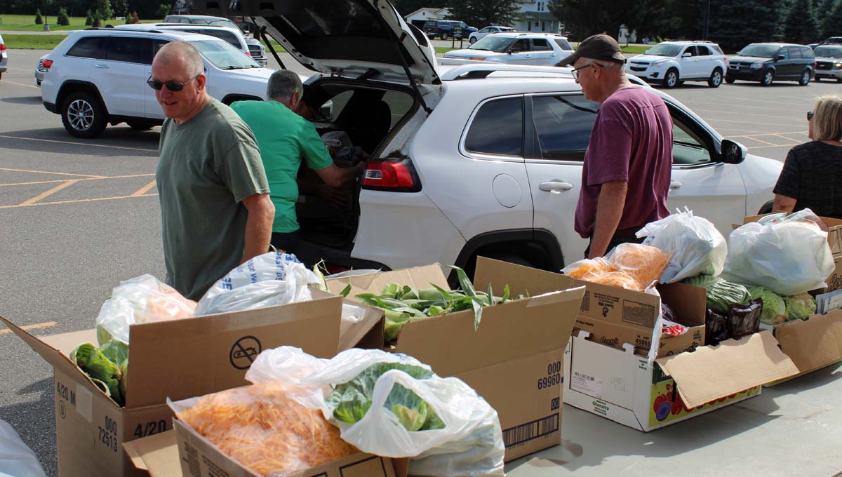 Community members help load food into vehicles at the monthly food pantry at Hamilton Middle School.