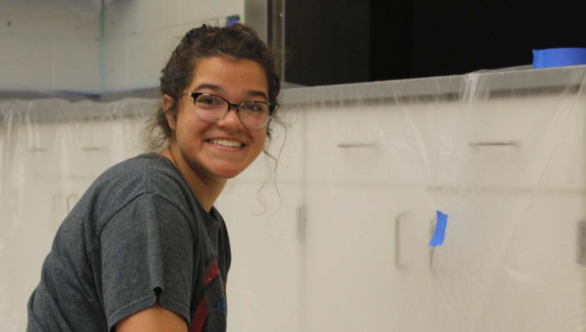 Hamilton High School junior Jordyn Deters prepares to paint the kitchen at Blue Star Elementary.