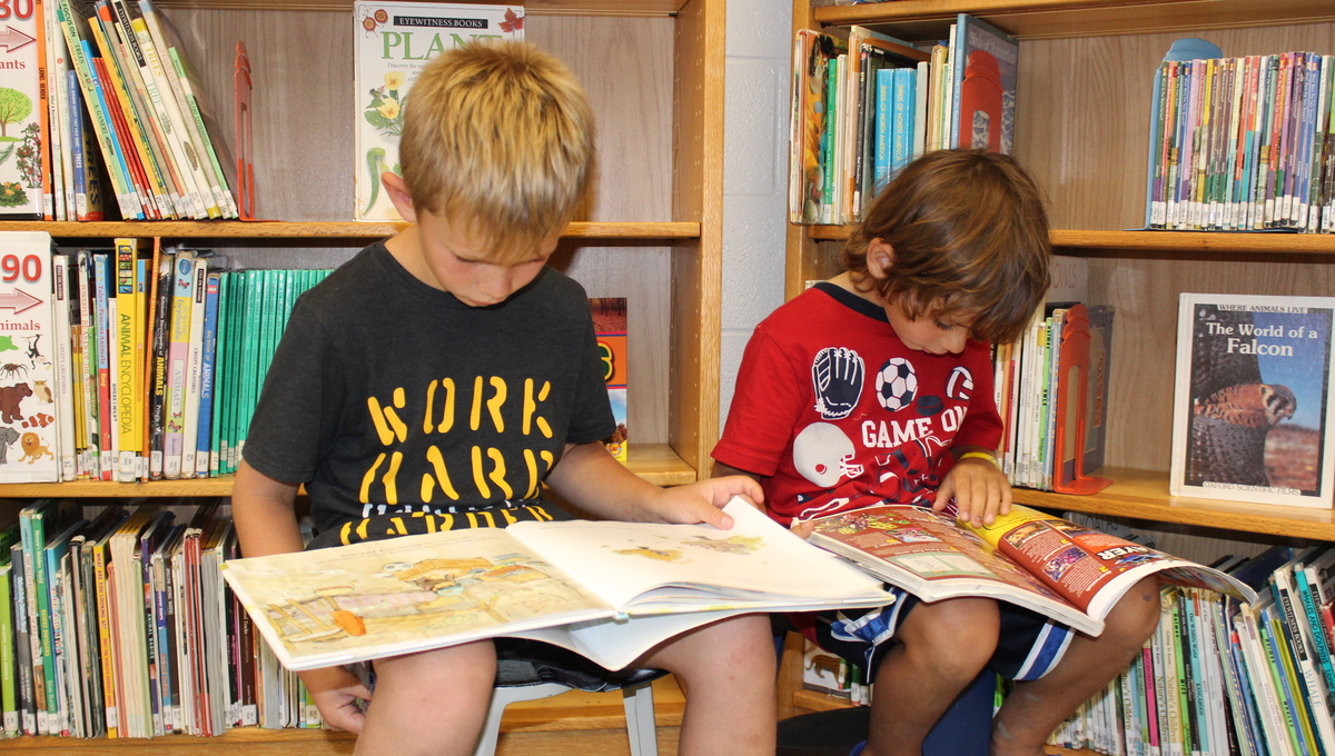 Children reading books at the summer reading library.